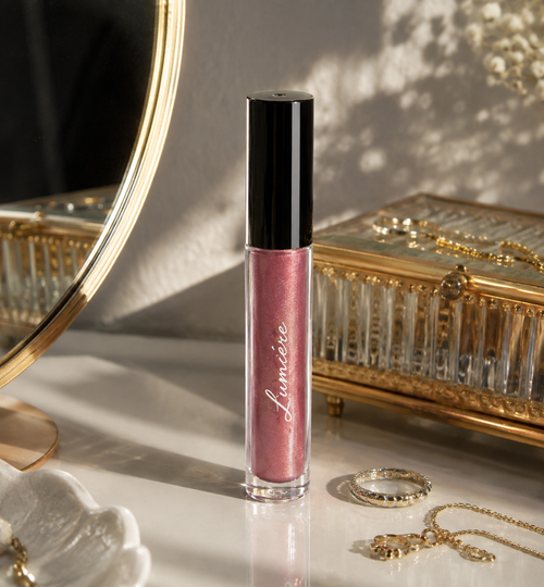Lumière Mauve Glow lip gloss on a marble vanity