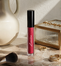 Lumière Ruby Glitz lip gloss on a marble vanity