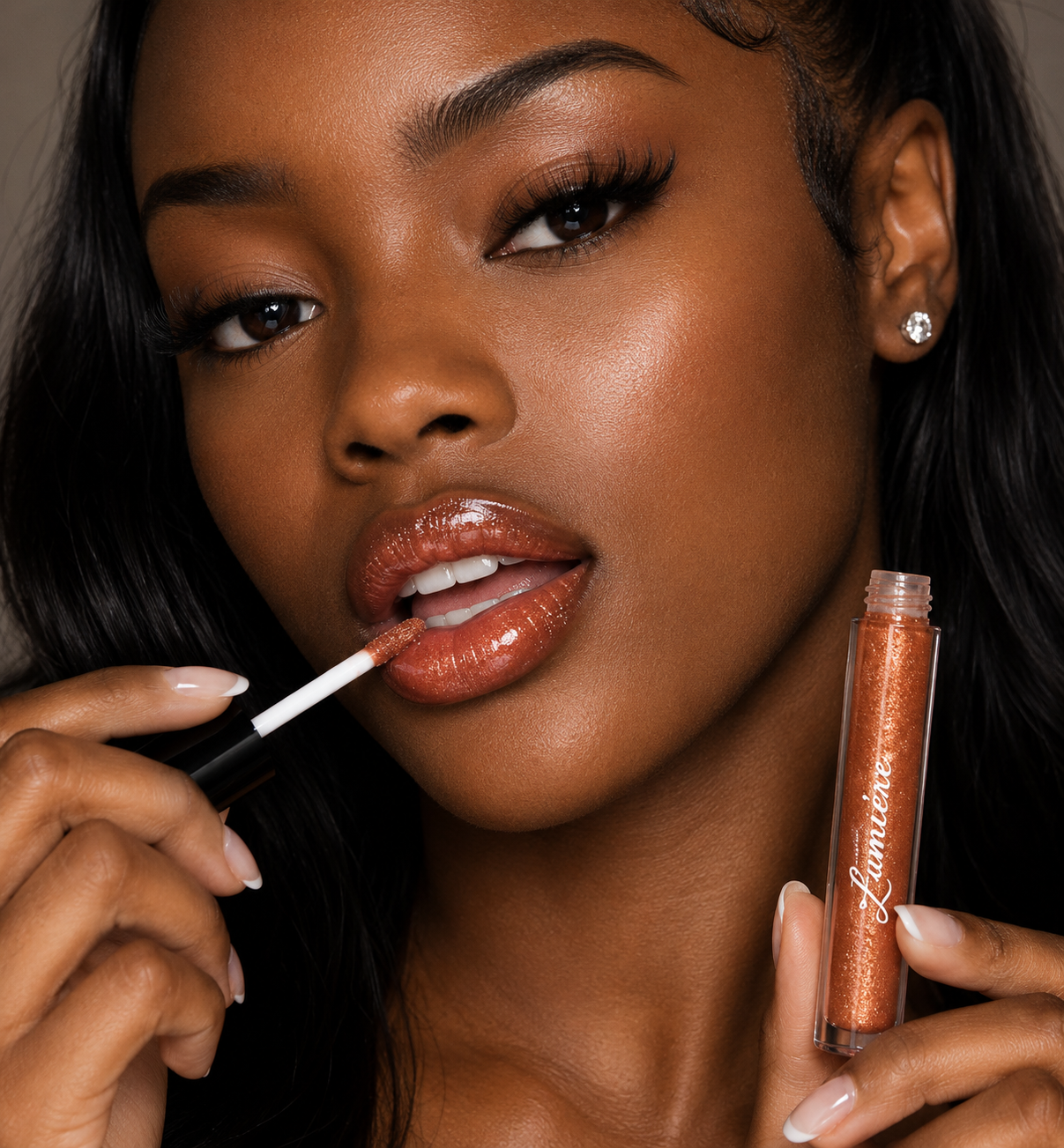 Model applying Lumière Gilded Copper lip gloss